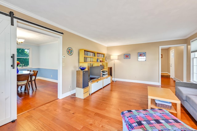 living room featuring a barn door, a baseboard heating unit, hardwood / wood-style flooring, and ornamental molding