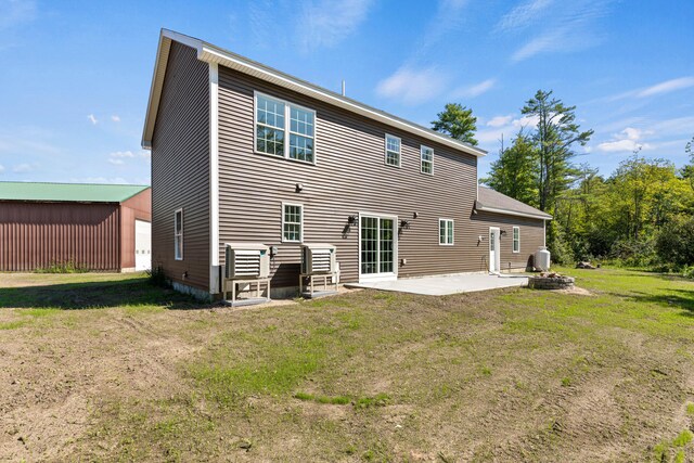 back of house with a lawn and a patio