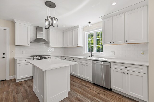 kitchen with white cabinets, backsplash, appliances with stainless steel finishes, wall chimney exhaust hood, and dark wood-type flooring