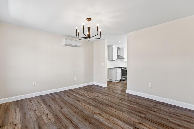 unfurnished dining area with an inviting chandelier, hardwood / wood-style floors, and a wall mounted air conditioner