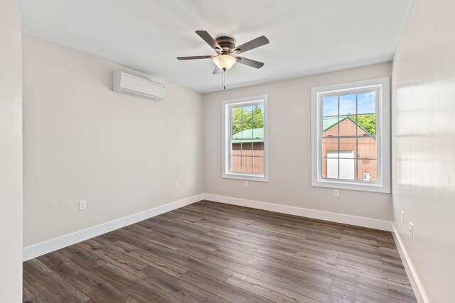 unfurnished room featuring a wall mounted AC, ceiling fan, and dark hardwood / wood-style floors