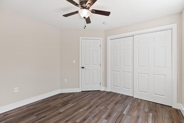 unfurnished bedroom with a closet, ceiling fan, and dark hardwood / wood-style floors