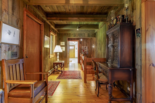 corridor featuring light wood-type flooring, wood walls, wooden ceiling, and beamed ceiling