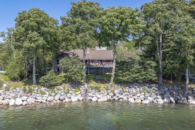 back of property featuring a water view