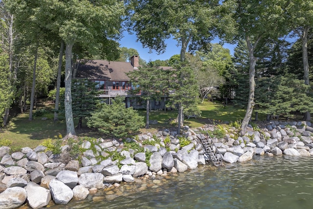 exterior space with a water view and a chimney