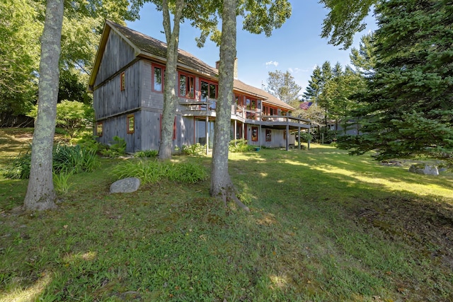 rear view of house with a deck and a yard