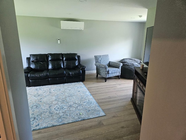 living room featuring light wood-type flooring and a wall unit AC