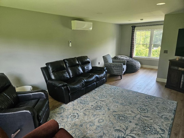 living room featuring light wood-type flooring and a wall unit AC