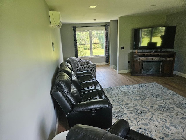 living room with hardwood / wood-style flooring and an AC wall unit