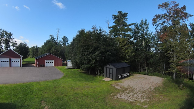 view of yard featuring a storage shed and a garage