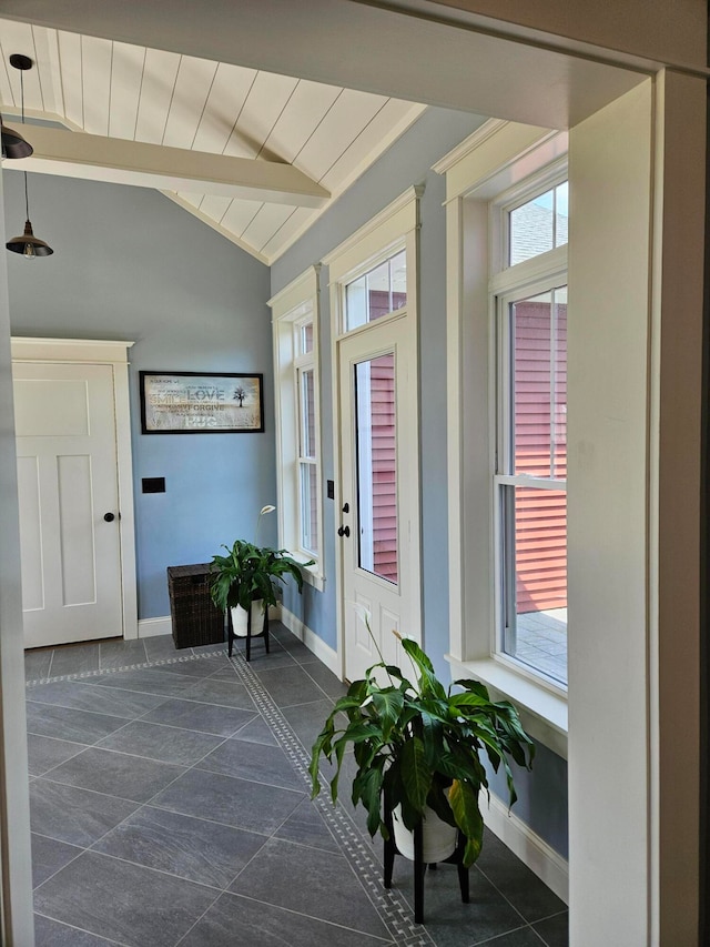 tiled entryway with lofted ceiling with beams and a wealth of natural light