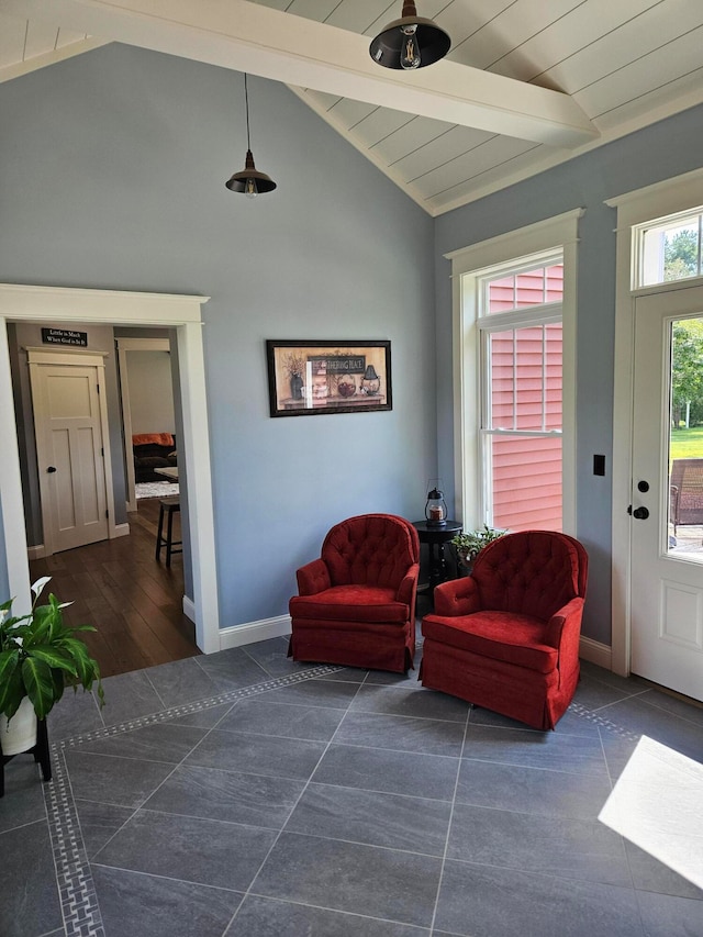 living area with vaulted ceiling with beams and dark tile patterned floors