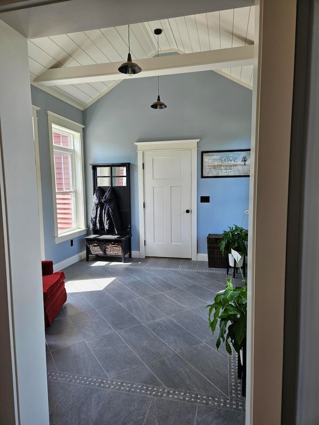 entryway with dark tile patterned flooring and lofted ceiling with beams