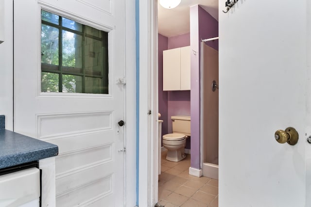 bathroom featuring tile patterned flooring, a shower, vanity, and toilet