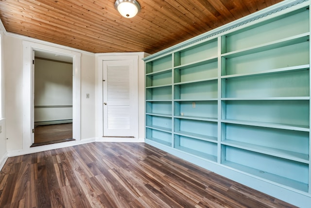 empty room featuring built in shelves, baseboard heating, dark wood-type flooring, and wooden ceiling