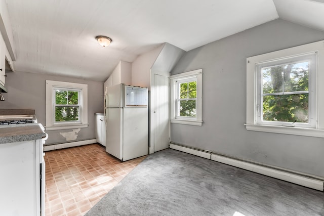 kitchen with a baseboard radiator, white fridge, and a wealth of natural light