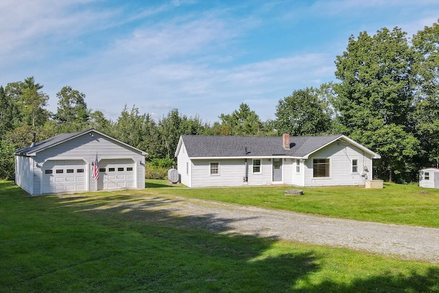 ranch-style home featuring an outbuilding, a garage, and a front yard