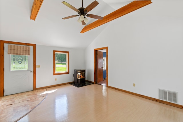 unfurnished living room featuring light wood-type flooring, a wood stove, ceiling fan, high vaulted ceiling, and beam ceiling