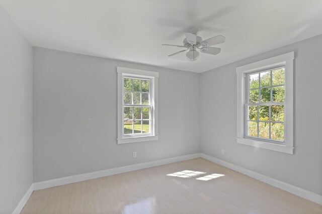 spare room featuring plenty of natural light, ceiling fan, and light hardwood / wood-style flooring