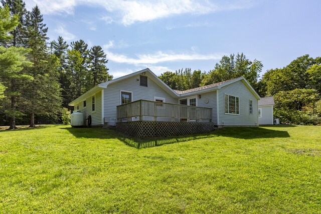 rear view of house featuring a yard and a deck