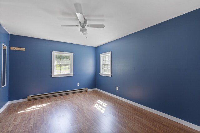 unfurnished room featuring baseboard heating, hardwood / wood-style flooring, and ceiling fan