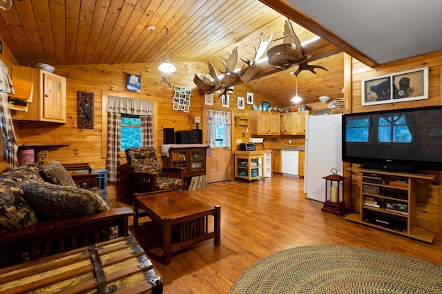 living room featuring wooden walls, vaulted ceiling, plenty of natural light, and light wood-type flooring