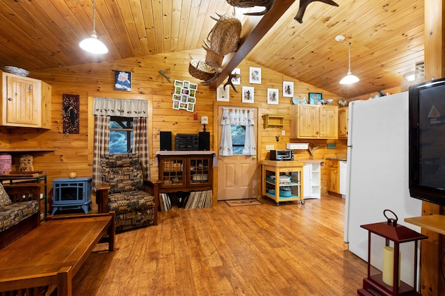 kitchen with wooden walls, hanging light fixtures, light hardwood / wood-style floors, and lofted ceiling