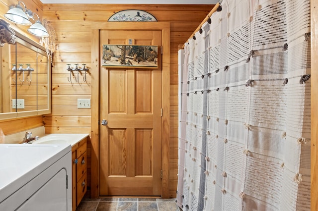 bathroom with tile patterned flooring, wooden walls, vanity, and a shower with curtain