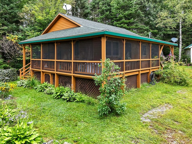 rear view of house with a sunroom and a yard