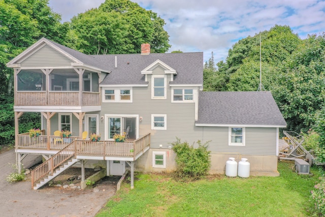 back of house with a sunroom, central air condition unit, and a lawn