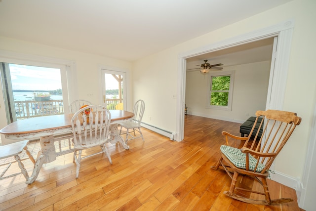 dining room with ceiling fan, light wood-type flooring, plenty of natural light, and baseboard heating