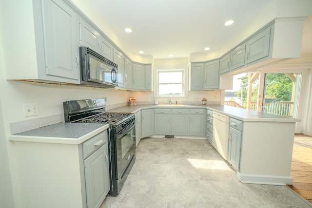 kitchen featuring kitchen peninsula, light hardwood / wood-style floors, black appliances, and sink