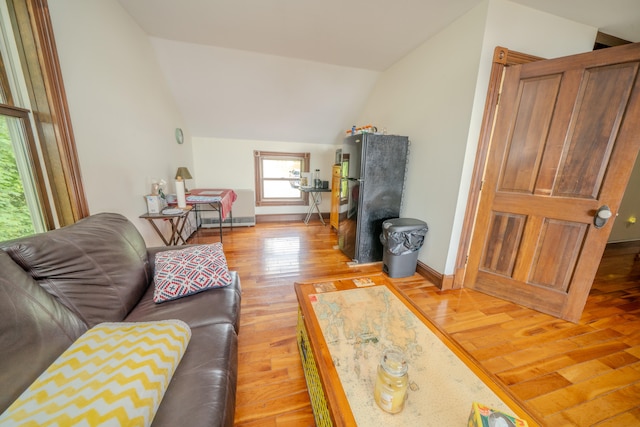 living room featuring light hardwood / wood-style flooring and vaulted ceiling