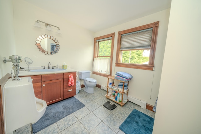 bathroom with toilet, a baseboard heating unit, vanity, and tile patterned floors