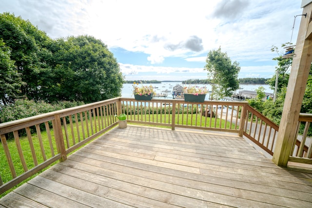 deck with a lawn and a water view