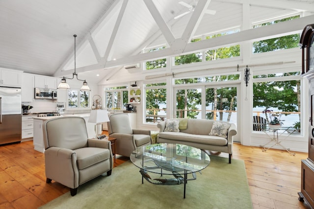 interior space featuring beamed ceiling, high vaulted ceiling, and light hardwood / wood-style floors