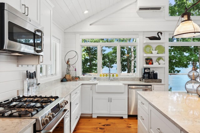 kitchen featuring light hardwood / wood-style flooring, vaulted ceiling, sink, appliances with stainless steel finishes, and white cabinets