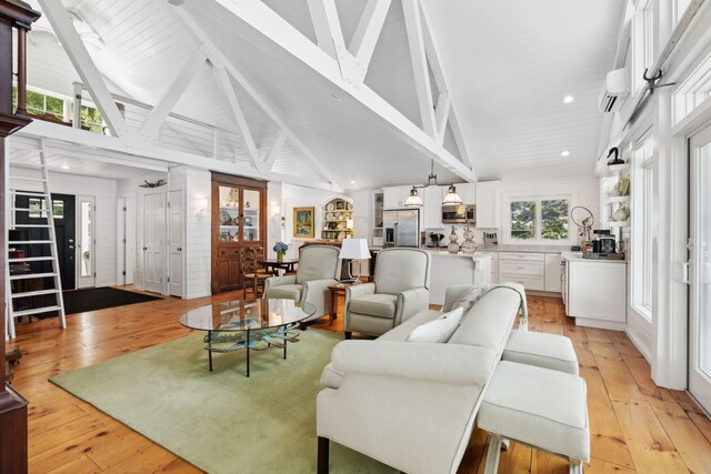 living room with high vaulted ceiling, beam ceiling, and light hardwood / wood-style flooring