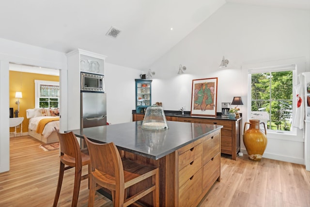 kitchen with plenty of natural light, stainless steel appliances, a center island, and light wood-type flooring