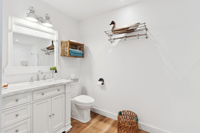 bathroom featuring a shower with shower curtain, toilet, hardwood / wood-style flooring, and vanity