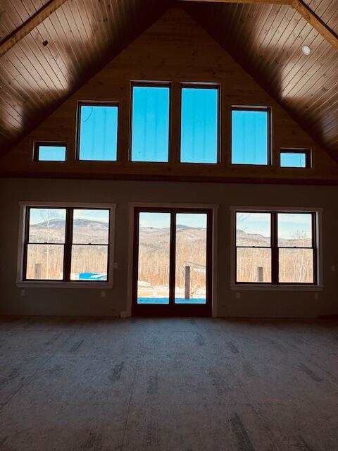 interior space featuring wood ceiling, high vaulted ceiling, and a wealth of natural light