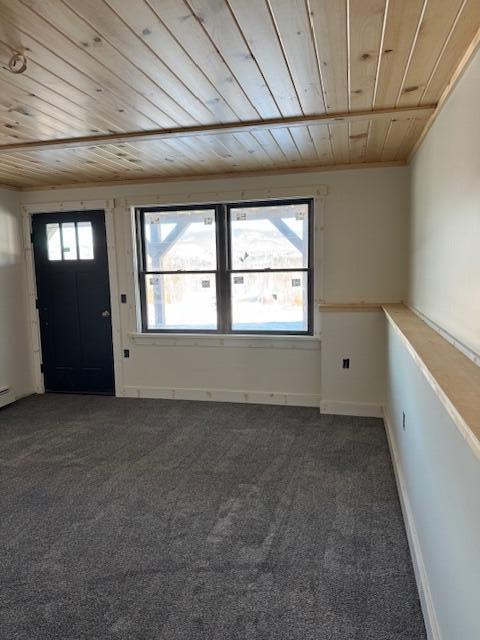 carpeted entryway featuring wooden ceiling