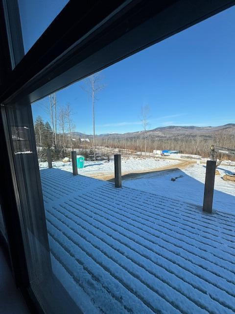 snow covered patio with a mountain view