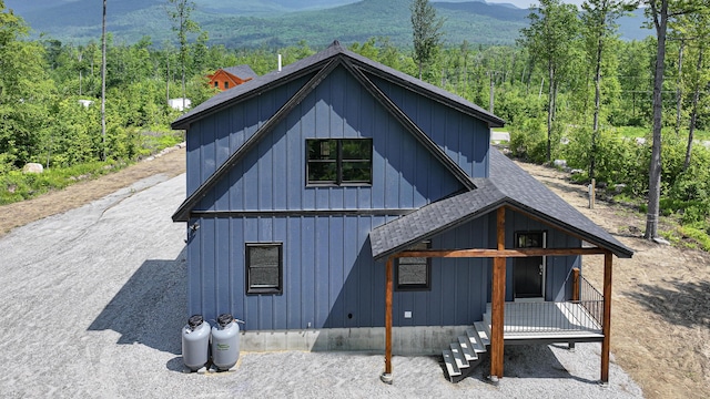 48 Harmony Row, Bethel, ME 04217 - view of side of property featuring a shingled roof, board and batten siding, a mountain view, and a forest view