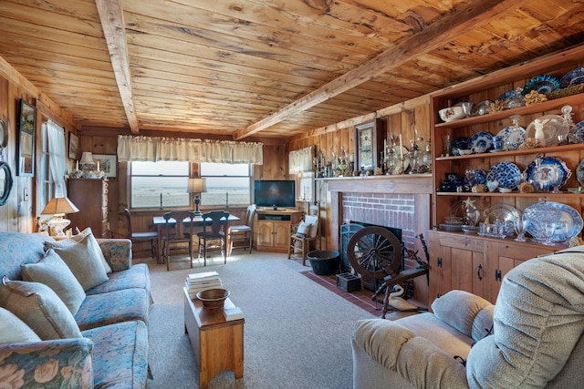 carpeted living room with wooden ceiling, beam ceiling, wood walls, and a fireplace