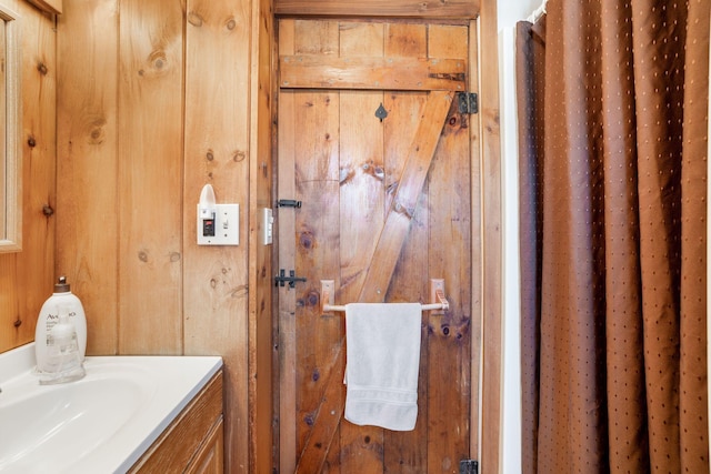 bathroom featuring wood walls and vanity