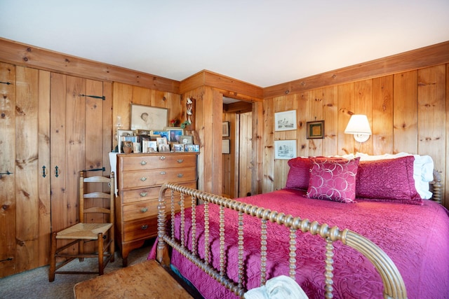 bedroom with carpet floors and wood walls