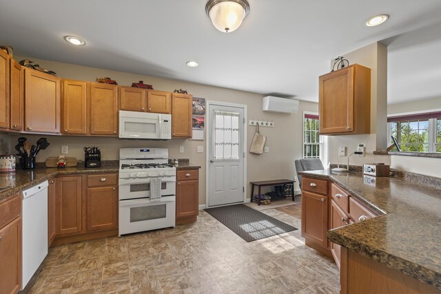 kitchen featuring a wall mounted AC and white appliances