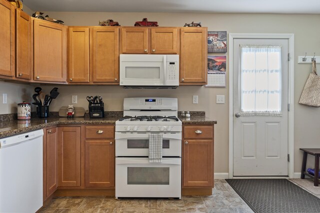 kitchen with dark stone counters and white appliances