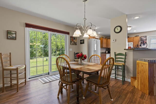 dining area featuring a wealth of natural light, dark wood-type flooring, and a chandelier